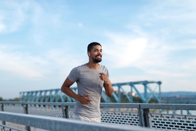 Man jogging on a bridge during a cardio workout to support heart health