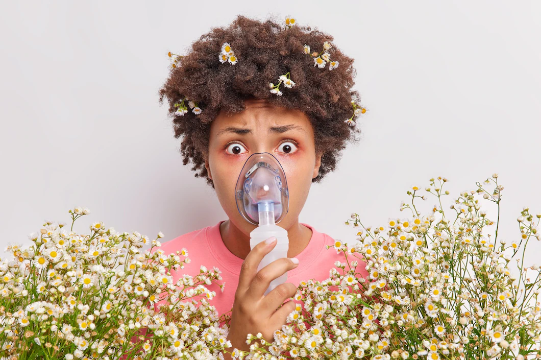 Woman using a nebulizer while surrounded by white flowers, promoting respiratory health and natural wellness.